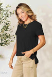 Trendsi women's basic black t-shirt on smiling model, relaxed short sleeve fit with side slit and beige pants