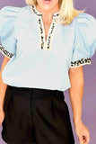 Trendy light blue leopard trim puff sleeve blouse with keyhole neckline paired with black trousers
