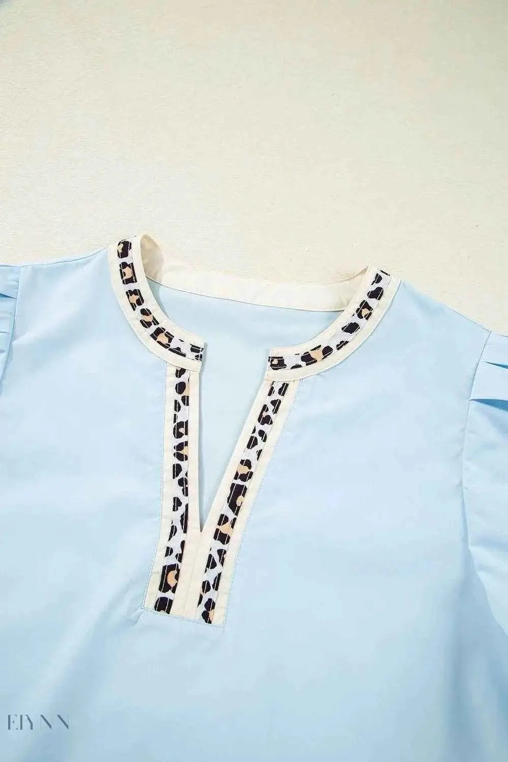 Trendy light blue leopard trim puff sleeve blouse with round neckline and front slit for casual wear