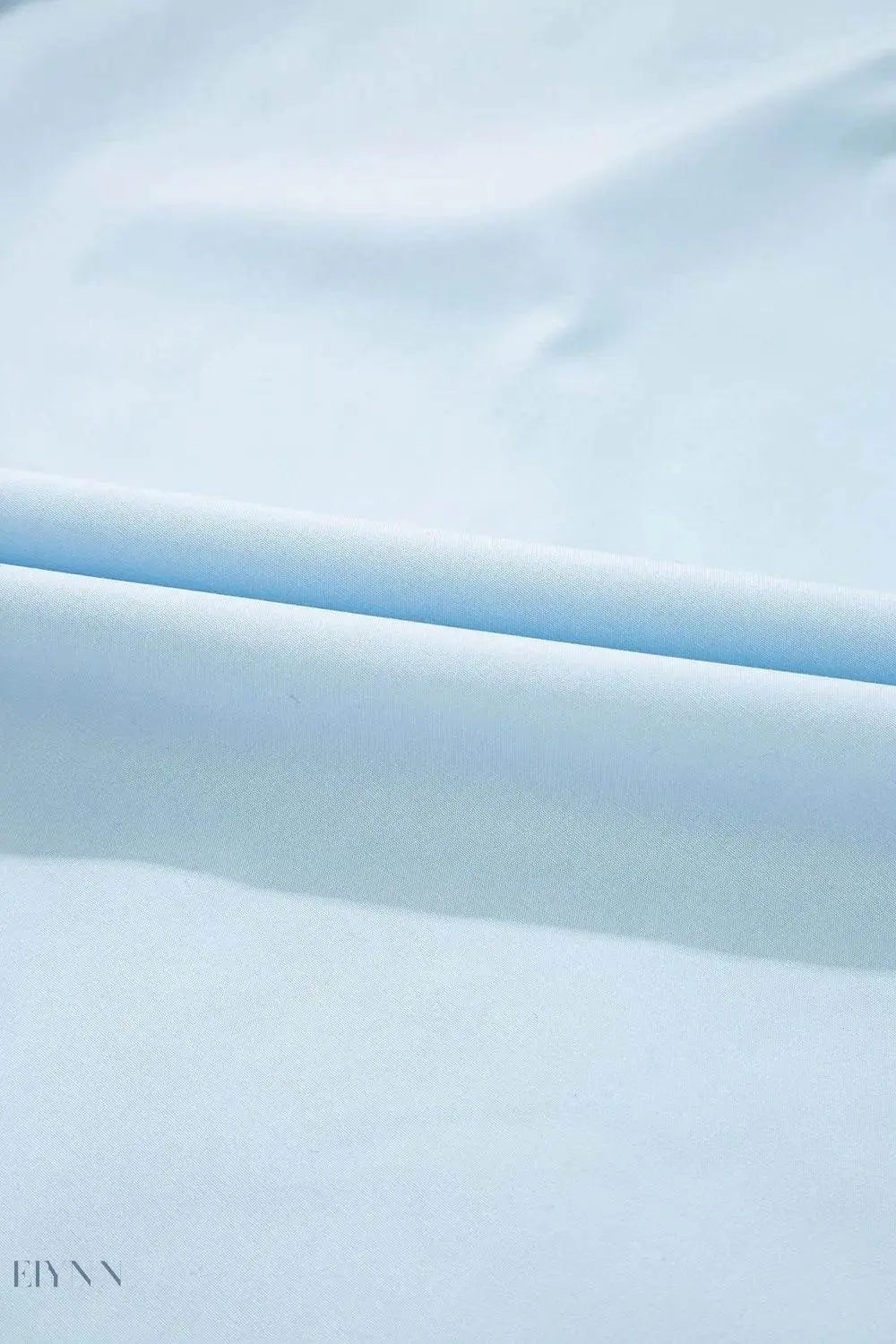 Trendy leopard trim puff sleeve blouse light blue fabric closeup showing smooth texture