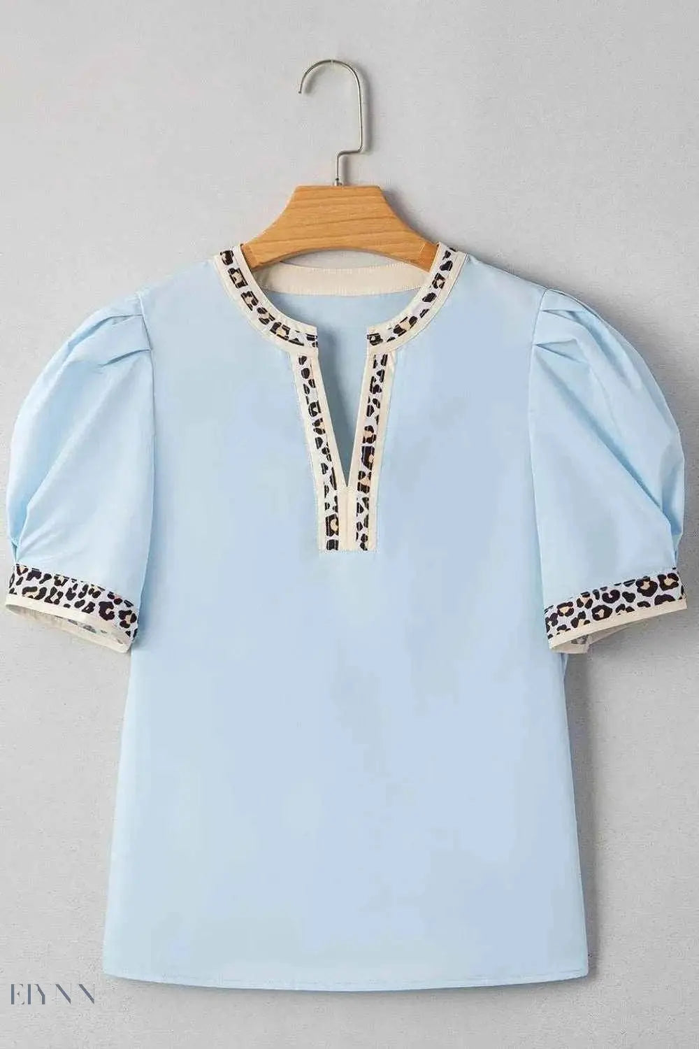 Trendy light blue leopard trim puff sleeve blouse with short puff sleeves and contrast leopard trim neckline and cuffs