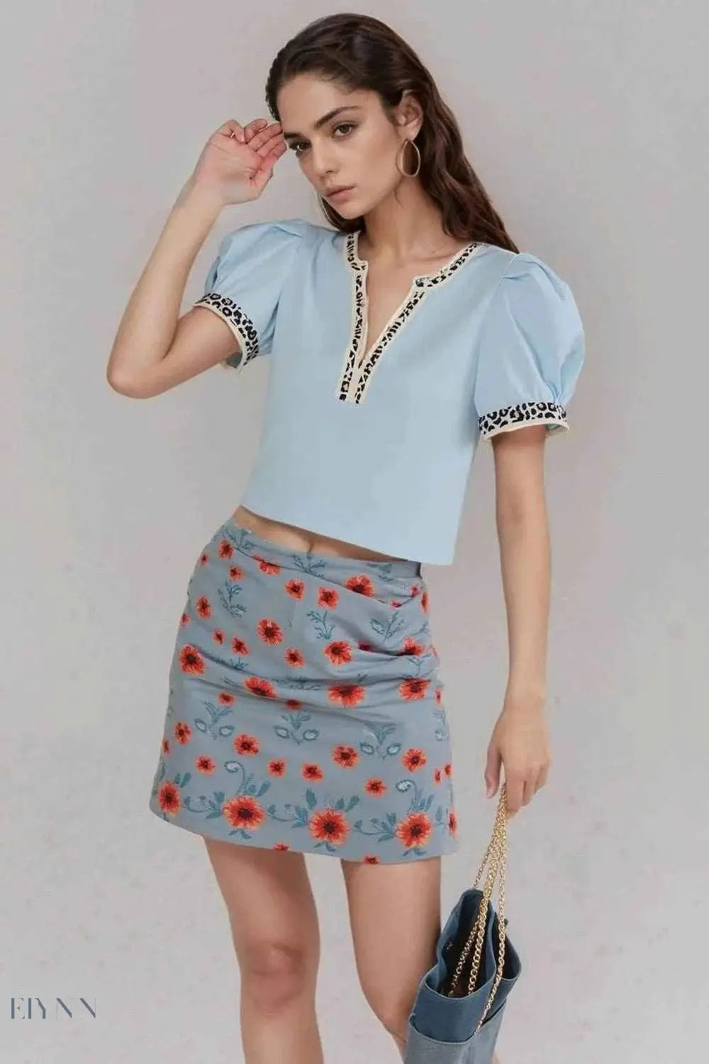 Trendy leopard trim puff sleeve blouse, light blue cropped V neck on model with floral skirt