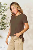 Smiling model wearing women's basic black t-shirt with gold necklaces and beige cargo pants