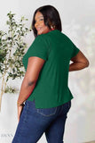 Plus size model wearing a short sleeve green top and jeans showcasing a women's basic black t-shirt listing by Trendsi