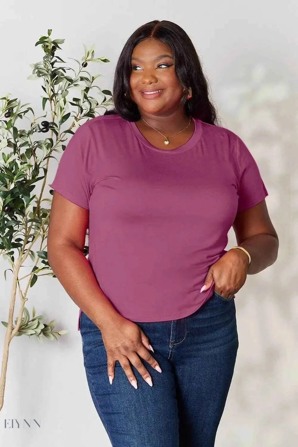 Plus size model wearing a plum crew neck tee and jeans, product variant labeled women's basic black t-shirt on Trendsi