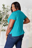 Plus size model wearing teal crewneck t shirt back view with jeans smiling for women's basic black t-shirt listing